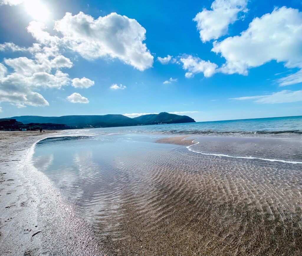 Spiaggia incontaminata del Golfo di Baratti con mare cristallino e cielo terso, ideale per vacanze a Suvereto.