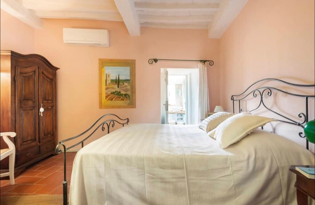 Camera accogliente Casa Vacanze Suvereto, letto matrimoniale, arredamento rustico, atmosfera rilassante.