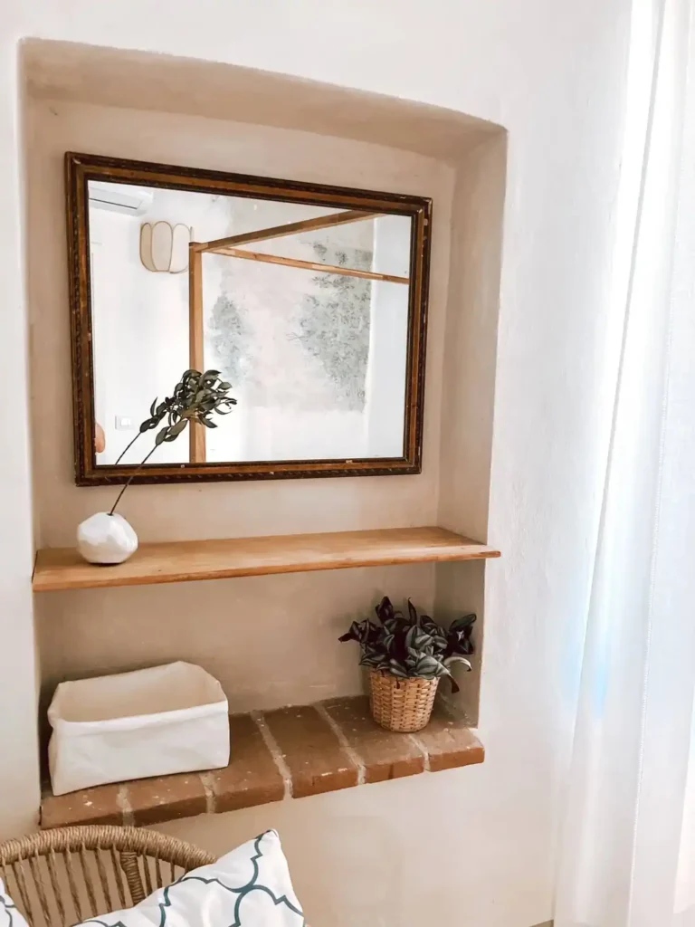 Angolo decorativo in casa vacanze Suvereto con specchio, mensola e pianta. Atmosfera accogliente in Val di Cornia.