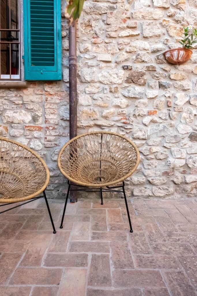 Terrazza rustica con sedie in vimini nel borgo storico di Suvereto, ideale per relax in vacanza.