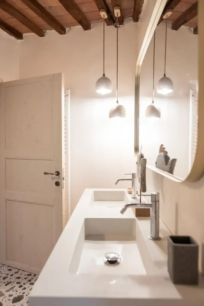 Bagno elegante con doppio lavabo e luci sospese a Casa Vacanze Suvereto, Val di Cornia.