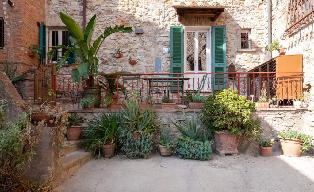 Facciata rustica con terrazza fiorita di casa vacanze nel borgo medievale di Suvereto.