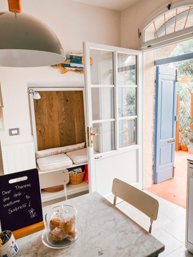 Interno accogliente di una casa vacanze a Suvereto, con tavolo marmoreo e accesso a patio soleggiato.