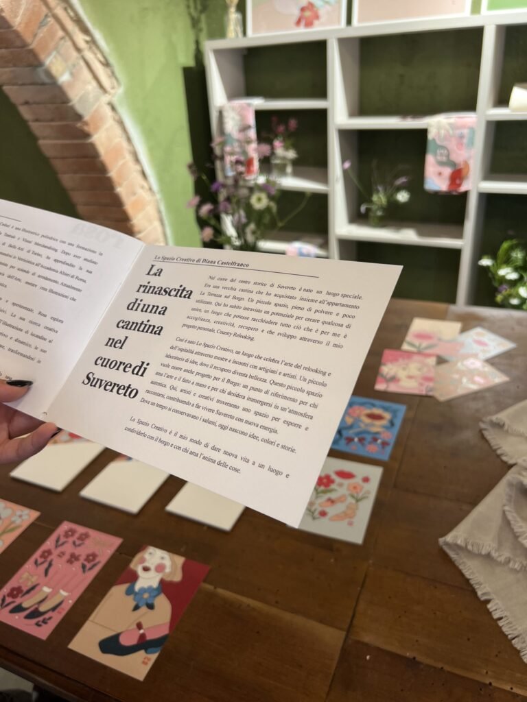 Spazio creativo a Suvereto, arte su tavolo di legno con sfondo di scaffali e decorazioni floreali.